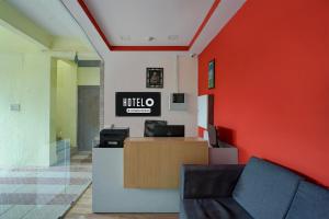 un vestíbulo de un hotel con una pared roja en Hotel O Thanisandra Railway Station Formerly Urban Drift, en Yelahanka