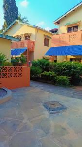 a house with blue awnings and a patio at Zion Apartment Diani in Diani Beach +14 photos