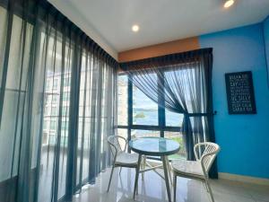 a table and chairs in a room with a window at IMAGO The Loft Kota Kinabalu City Centre by LW Suites in Kota Kinabalu