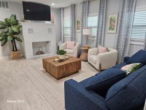 een woonkamer met een blauwe bank en een open haard bij Heavenly Hideaway in Holly Hill