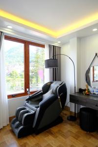 - un fauteuil inclinable noir dans une chambre avec fenêtre dans l'établissement Monaco Hotel, à Sa Pa