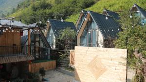 eine Reihe von Häusern mit einem Berg im Hintergrund in der Unterkunft Pavi Lodge in Mèo Vạc