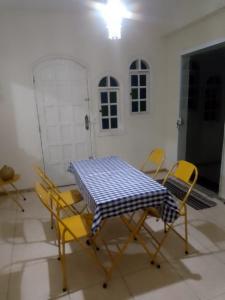 un tavolo con sedie gialle e una tovaglia a quadri blu e bianchi di Casa Petrópolis a Petrópolis