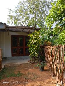 a house with a wooden door and a fence at DiDi Eco Home in Weligama