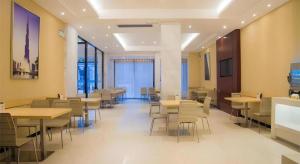 a dining room with tables and chairs in a building at City Comfort Inn Liuzhou High-speed Railway Station in Liuzhou