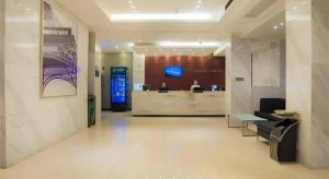 a lobby of a hotel with two people at a counter at City Comfort Inn Liuzhou High-speed Railway Station in Liuzhou