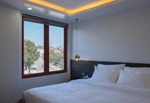 a bedroom with a large bed with a large window at Monaco Hotel in Sapa