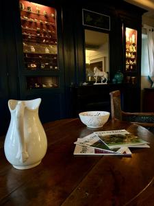 - une table avec un vase blanc et un bol dans l'établissement Moulin de Champrond -Montmirail -Sarthe, à Champrond