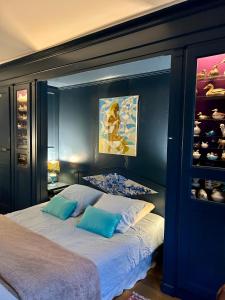 un lit avec deux oreillers dans une chambre bleue dans l'établissement Moulin de Champrond -Montmirail -Sarthe, à Champrond