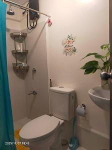 une salle de bains avec toilettes et lavabo dans l'établissement JC Palace Residence, à Manille