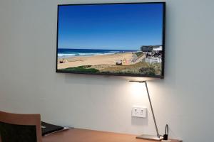 a flat screen tv hanging on a wall at Colonial Terrace Motor Inn in Raymond Terrace