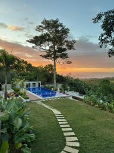 a backyard with a swimming pool and a lawn at Everleigh Resort in Mataasnakahoy