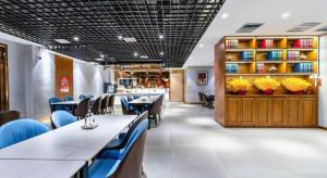 a restaurant with blue chairs and tables in a room at James Joyce Coffetel Tianjin Railway Station in Tianjin