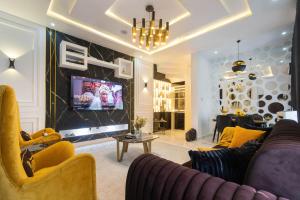 a living room with a couch and a tv at Modern 3BR Smart Villa near Lekki Conservation with Inverter PS5, Hot Tub and Gym in Ibeju