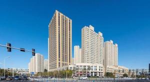 a group of tall buildings in a city at James Joyce Coffetel Harbin West High-speed Railway Station Wanda Plaza in Harbin