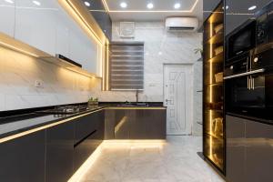 a kitchen with stainless steel appliances and a stove at Modern 3BR Smart Villa near Lekki Conservation with Inverter PS5, Hot Tub and Gym in Ibeju