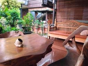 Ein Pinguin sitzt auf einem Tisch in einem Raum mit einer Bank. in der Unterkunft Puri Asri Bungalow Ubud in Ubud