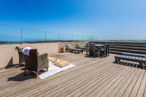 una terraza con sillas y mesas en la parte superior de un edificio en 216-Koi living Ballito, en Ballito