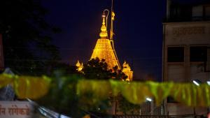 a tall building with a lit up tower in the background at Hotel Golden View in Shirdi