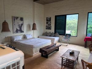 a bedroom with two beds and a couch and a table at Silvaate stay in Karjat