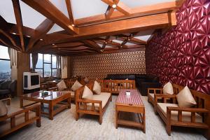 een restaurant met tafels en banken en een muur met rood bij Hotel De Universal in Kathmandu