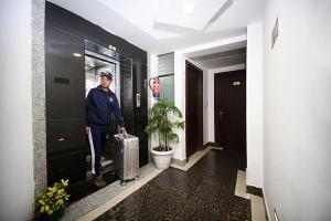 Een man staat in een gang met een koffer. bij Hotel De Universal in Kathmandu