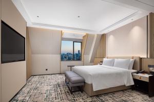 武漢市にあるWANDA YI Wuhanのベッドと大きな窓があるホテルの部屋 +39枚の写真
