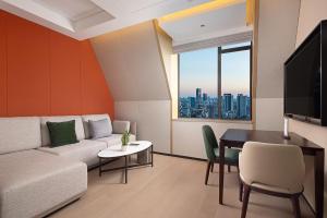 武漢市にあるWANDA YI Wuhanのソファとテーブルのあるリビングルーム