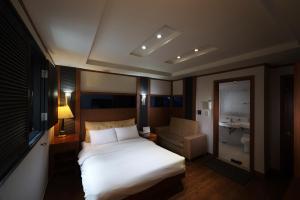 首爾的住宿－驛三貴族酒店，卧室配有白色的床和椅子