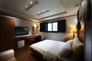 a bedroom with a bed and a flat screen tv at Hotel Noblesse, Yeoksam in Seoul