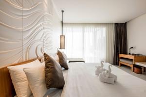 a bedroom with a bed with two swans on it at G Hua Hin Resort & Mall - SHA Extra Plus in Hua Hin