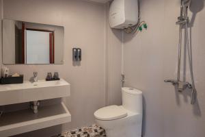 une salle de bains blanche avec toilettes et lavabo dans l'établissement Monaco Hotel, à Sa Pa