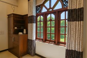 een kamer met een groot raam met gordijnen bij Grand Villa Kalametiya in Kalametiya