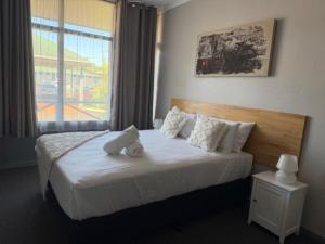 ein Schlafzimmer mit einem Bett, auf dem ein Teddybär liegt in der Unterkunft Dawson Motel in Lismore