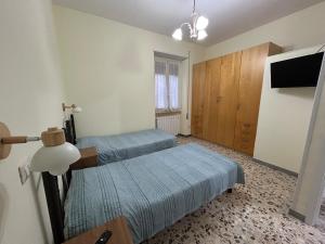 ein Zimmer mit zwei Betten und einem Flachbildfernseher in der Unterkunft Casetta Luigina in Monterotondo