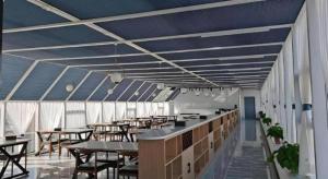 ein Esszimmer mit Tischen, Stühlen und blauen Decken in der Unterkunft GreenTree Inn Express Liaoning Jinzhou Bijia Mountain in Dandong