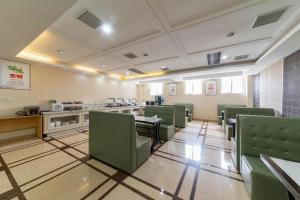 a waiting room with green chairs and tables at GreenTree Alliance Hotel Yancheng Engineering College Dayangwan Scenic Area in Ti-pa-yung