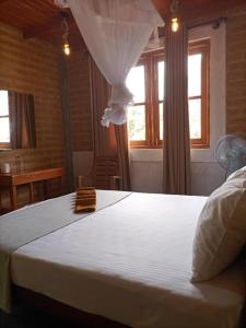 a bedroom with a large white bed with a window at DiDi Eco Home in Weligama +30 photos