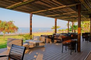 a patio with chairs and tables and a view of the beach at Sural Hotel in Side