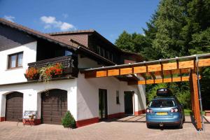 una piccola auto parcheggiata di fronte a una casa di Ferienwohnung Siefert a Mossautal