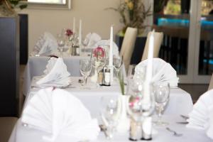 a white table with glasses and napkins on it at Kurhotel Pyramide Sibyllenbad in Neualbenreuth +19 photos