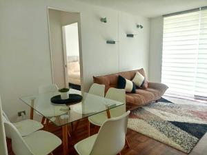 a living room with a couch and a glass table at Departamento en Pucón in Pucón +16 photos