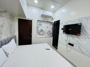 a bedroom with a bed and a tv on the wall at Hotel O Aundh Homtel in Dāpuri