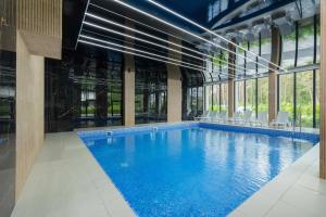a large swimming pool in a building with windows at Unique Studio with Parking Space and Swimming Pool by Noclegi Renters in Pobierowo