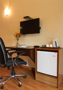 an office with a desk and a chair and a tv at Perch Arbor-Golf Course Road in Gurgaon