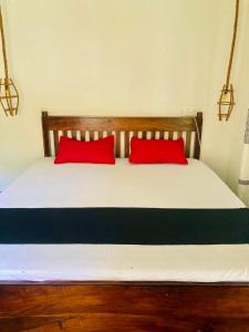 een bed met twee rode kussens erop bij Relax point cabana & restaurant in Netolpitiya