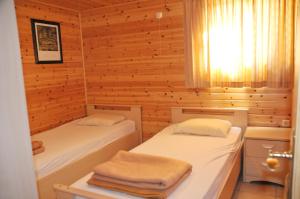 2 łóżka w pokoju z drewnianymi ścianami w obiekcie Les Rochettes Vénus 2 w La-Roche-en-Ardenne