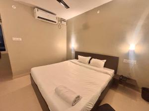 a bedroom with a bed with white sheets and pillows at Townhouse Indira Gandhi Athletic Stadium Guwahati Formerly Cloud Stay Inn in Dispur +19 photos