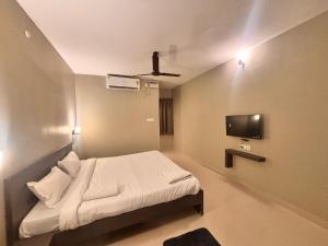 a small room with a bed and a tv at Townhouse Indira Gandhi Athletic Stadium Guwahati Formerly Cloud Stay Inn in Dispur