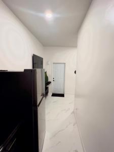 une pièce blanche avec un réfrigérateur noir et une porte dans l'établissement Elegant 1-Bedroom Retreat, à Miami